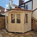 Breckland Heritage Corner Hipped summerhouse - painted finish Cornsilk, Cedar shingle roof & 1/2 length glazing